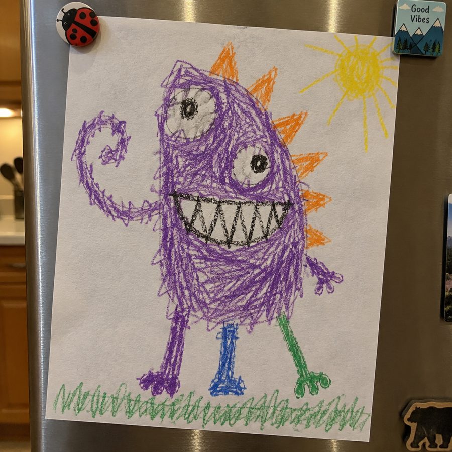 A child's purple crayon monster drawing held to a refrigerator with magnets